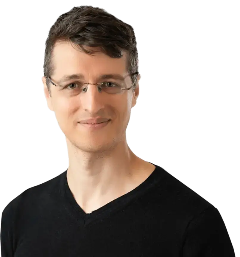 A man wearing glasses and a black shirt, looking directly at the camera with a neutral expression.