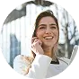 A woman smiles while holding a tablet computer, showcasing a positive and engaging expression.