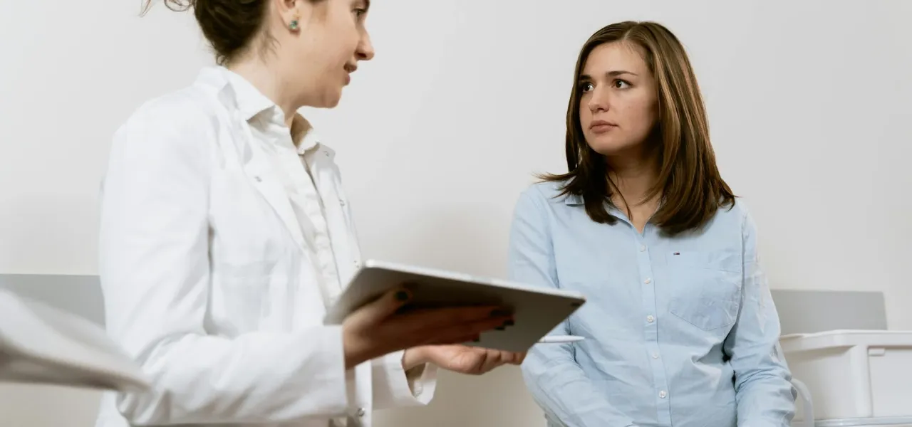 In a medical consultation, a woman speaks with a doctor
