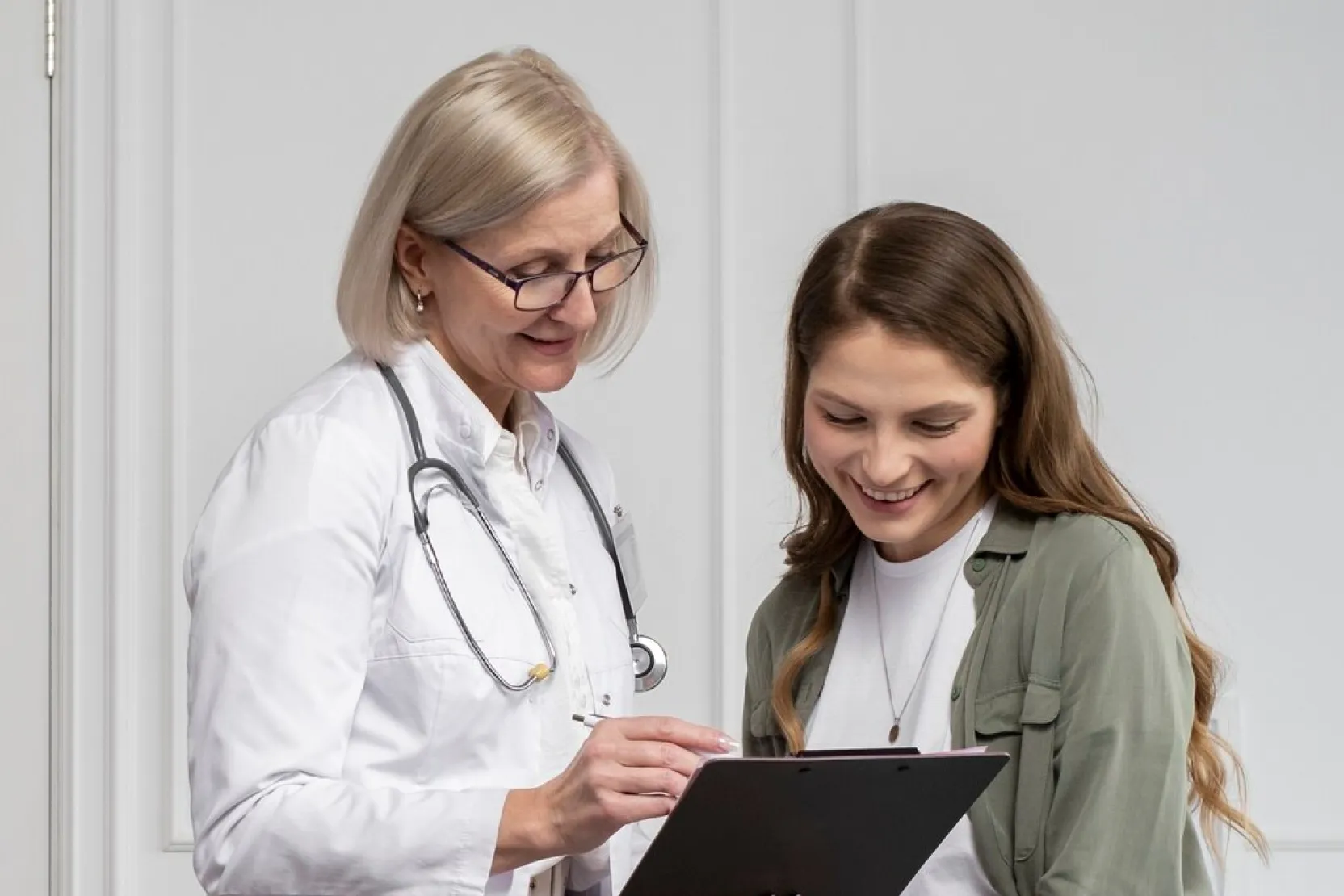 A provider in a white coat engages in conversation with a woman.