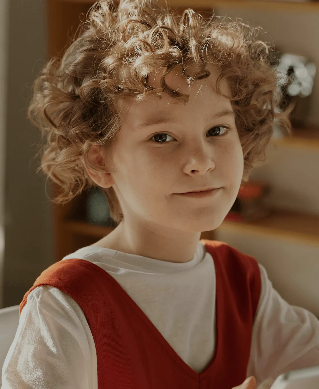 A young boy engaged with a laptop at a table, displaying concentration and curiosity.